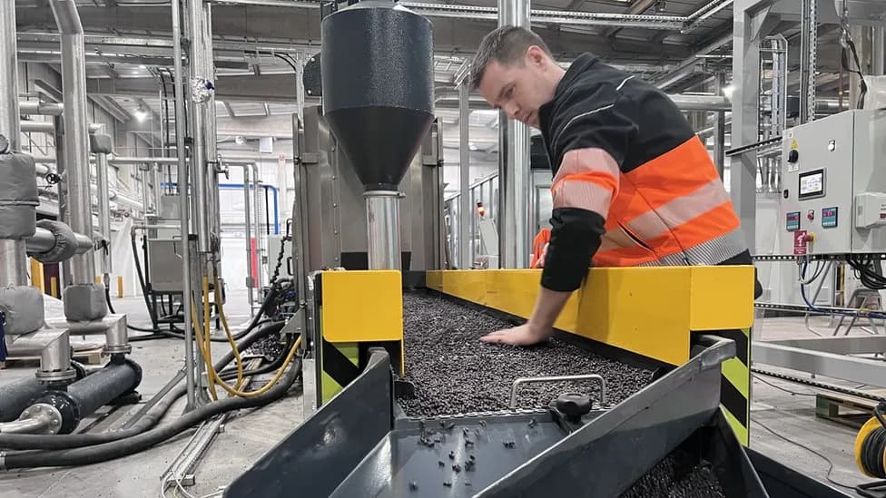 Image of worker inside facility surrounded by recycling machinery at Innovate Recycle, the first and only company in the UK to fully recycle end-of-life carpet at volume. Its flagship product is the Innovate rPP NORPLAS pellet range.